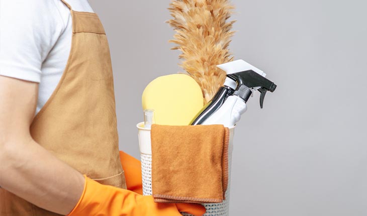 Housekeeper holding a caddy of cleaning supplies