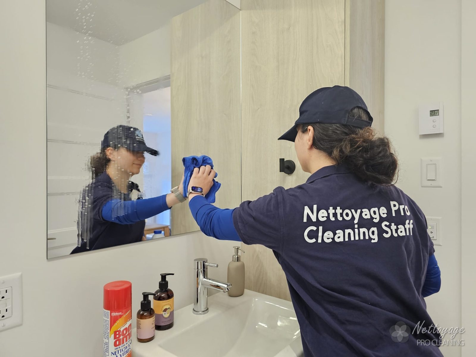 Membre de l'équipe polissant un miroir de salle de bain