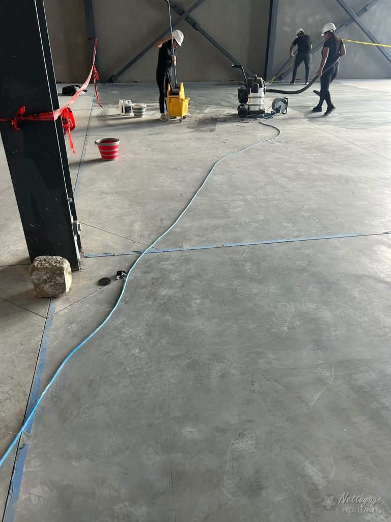 Cleaning team working on a post construction site with mop and industrial vacuum