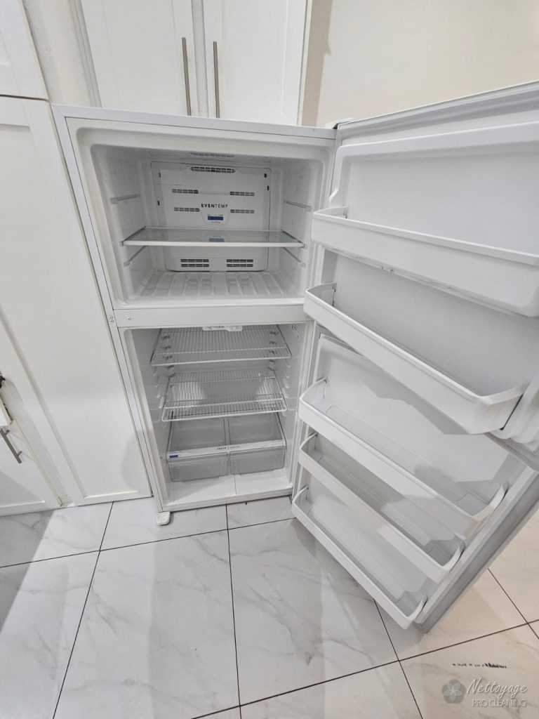 Spotless empty fridge interior after move out cleaning